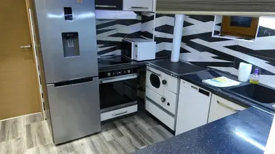 a kitchen with stainless steel appliances and black counter tops at Apartment Kraljica Jelena in Virpazar