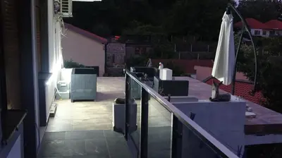a patio with an umbrella and tables and chairs at Apartment Kraljica Jelena in Virpazar