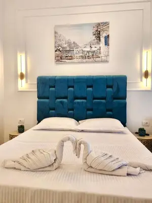 a blue headboard of a bed with two towels on it at Sunrise Apart-Hotel in Ulcinj