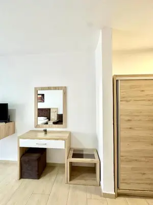 a bathroom with a wooden desk and a mirror at Sunrise Apart-Hotel in Ulcinj