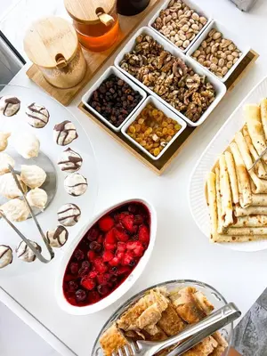 a white table topped with trays of food and desserts at Sunrise Apart-Hotel in Ulcinj