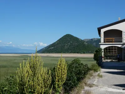 a building next to a field with mountains in the background at Accommodation 
