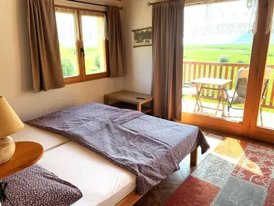a bedroom with a bed and a balcony with a table at Accommodation 