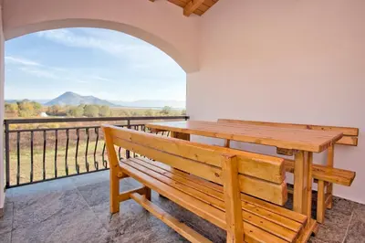 a wooden bench sitting on a balcony with a view at Accommodation 