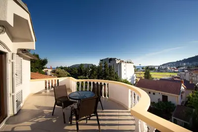 a balcony with chairs and a table on a building at Villa Vojnic in Budva