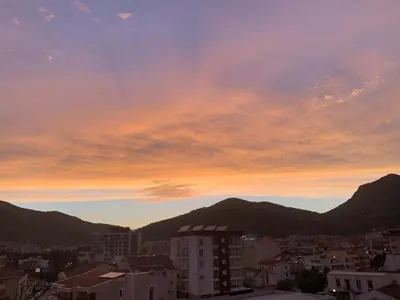 a view of a city at sunset with mountains at Villa Vojnic in Budva