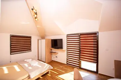 a small bedroom with a bed and a television at Villa Vojnic in Budva