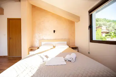 a bedroom with a bed with two towels and a window at Villa Vojnic in Budva