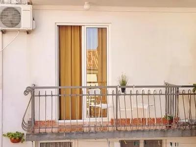a balcony of a house with a window at Studio apartman na plaži in Rafailovici