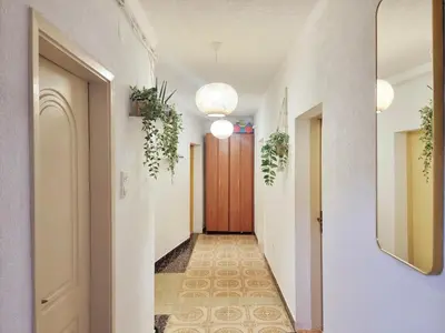 a hallway with white walls and a wooden door at Studio apartman na plaži in Rafailovici