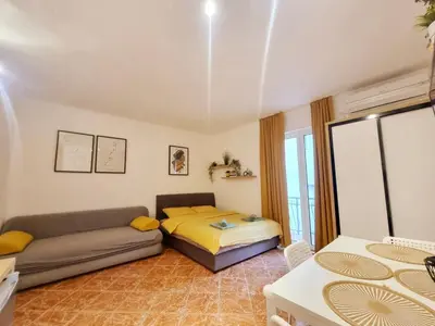 a living room with a bed and a couch at Studio apartman na plaži in Rafailovici