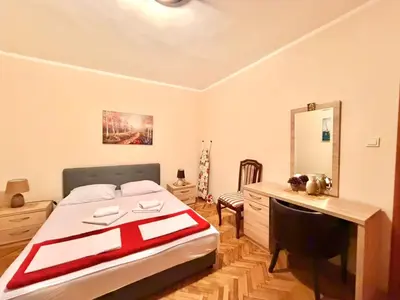 a bedroom with a bed and a desk and a mirror at Beachfront Apartments Oaza 1 in Petrovac na Moru