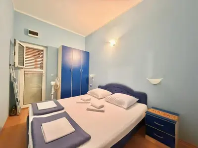 a bedroom with a bed with a blue wall at Beachfront Apartments Oaza 1 in Petrovac na Moru