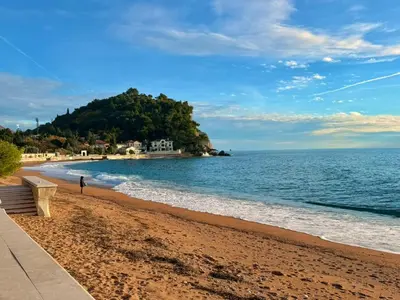 a person walking on a beach with the ocean at Beachfront Apartments Oaza 1 in Petrovac na Moru