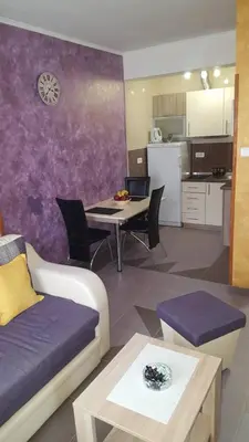 a living room with a couch and a table and a kitchen at Apartman Centar Lux in Budva