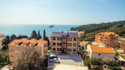 a group of buildings in a town next to the ocean at Apartments Monte Re in Petrovac na Moru