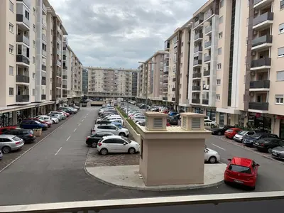 a parking lot full of parked cars in a city at Fanky City Apartments in Podgorica