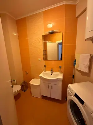 a bathroom with a sink and a washing machine at Apartmani Jedro in Rafailovici