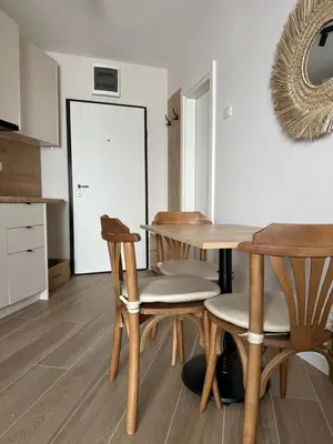 a kitchen with a table and chairs and a door at Apartmani Jedro in Rafailovici