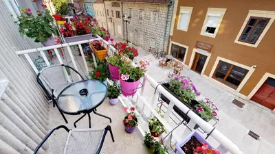 an apartment balcony with a table and flowers at Adagio apartment in Cetinje