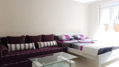 a living room with a purple couch and a glass table at Adagio apartment in Cetinje