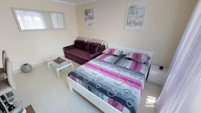 a bedroom with a bed and a purple couch at Adagio apartment in Cetinje