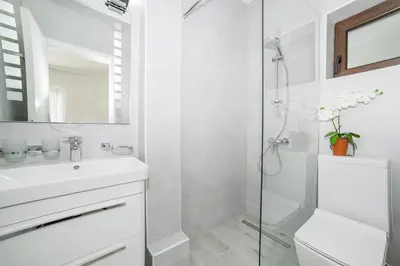 a white bathroom with a sink and a shower at Villa Mona 2 in Budva