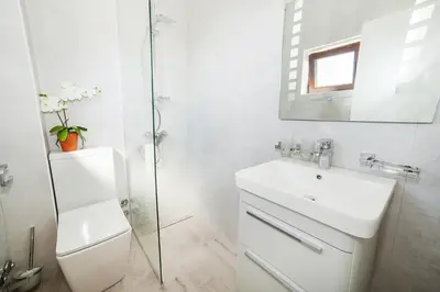 a white bathroom with a sink and a mirror at Villa Mona 2 in Budva