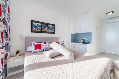 a white bedroom with a bed with white sheets and pillows at Villa Mona 2 in Budva