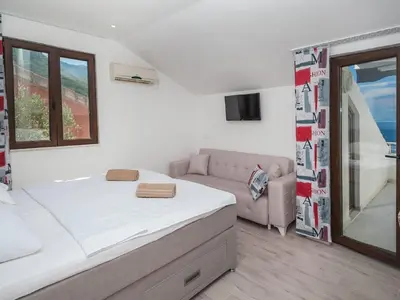 a white bedroom with a bed and a couch at Villa Mona 2 in Budva