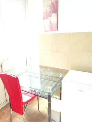 a glass table and a red chair in a kitchen at Sweet Dream Rooms in Podgorica