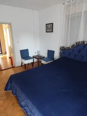 a bedroom with a blue bed and two chairs at Sweet Dream Rooms in Podgorica
