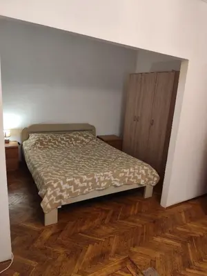 a bedroom with a bed and a wooden cabinet at Sweet Dream Rooms in Podgorica