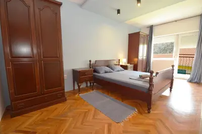 a bedroom with a bed and a wooden cabinet at Bugi in Kotor