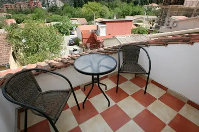 a patio with two chairs and a table on a balcony at Bugi in Kotor