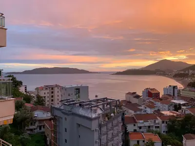 a city with a view of the ocean at sunset at Belveder Montenegro in Rafailovici