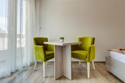 a table and two green chairs in a room at Al Mare apartments Budva in Budva