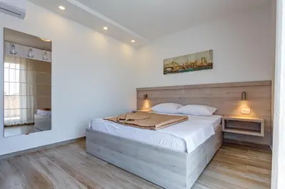 a bedroom with a large bed and a mirror at Al Mare apartments Budva in Budva
