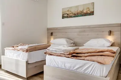 two beds sitting next to each other in a bedroom at Al Mare apartments Budva in Budva