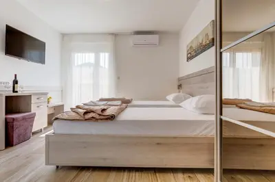 a bedroom with a bed and a mirror at Al Mare apartments Budva in Budva