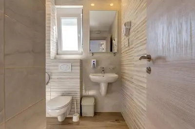 a bathroom with a toilet and a sink at Al Mare apartments Budva in Budva