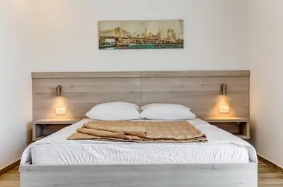 a bedroom with a bed with a wooden headboard at Al Mare apartments Budva in Budva