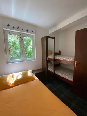 a bedroom with a bed and a mirror and a window at Apartment Tanya in Petrovac na Moru