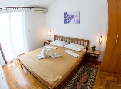a bedroom with a bed with a towel on it at Guest House Mandarina in Budva