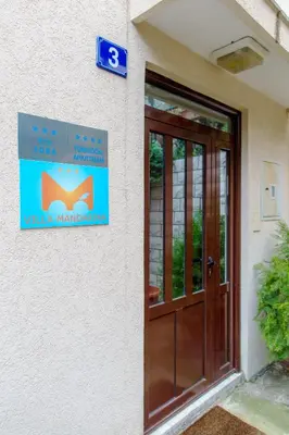 a sign on the side of a building with a door at Guest House Mandarina in Budva