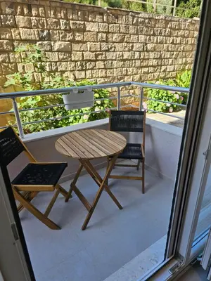 a wooden table and two chairs on a balcony at Anja & Ogo apartments with Pool 2 in Petrovac na Moru