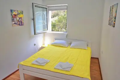 a bedroom with a yellow bed with a window at Dream Bay View Loki in Kotor
