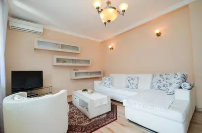 a living room with a white couch and a tv at Central Apartment in Kotor