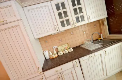 a kitchen with white cabinets and a sink at Central Apartment in Kotor