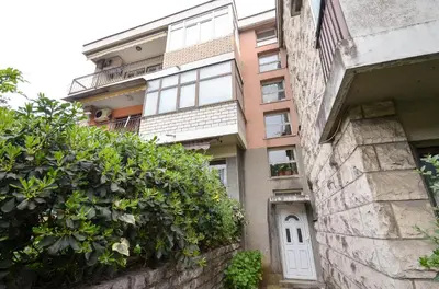 an apartment building with a white door and bushes at Central Apartment in Kotor